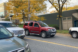 A red SUV driving on the wrong side of the road.